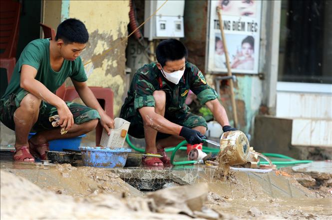Cán bộ, chiến sỹ Sư đoàn 324 giúp người dân xã Mường Xén khắc phục hậu quả mưa lũ. Ảnh: Văn Tý-TTXVN