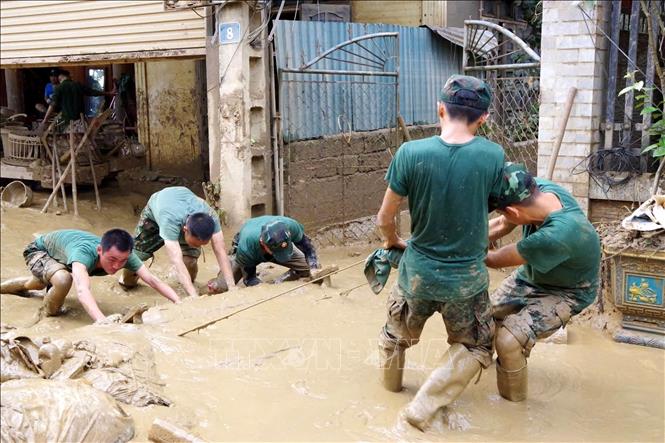 Lực lượng Sư đoàn 324 hỗ trợ người dân xã Tương Dương khắc phục hậu quả mưa lũ. Ảnh: TTXVN phát