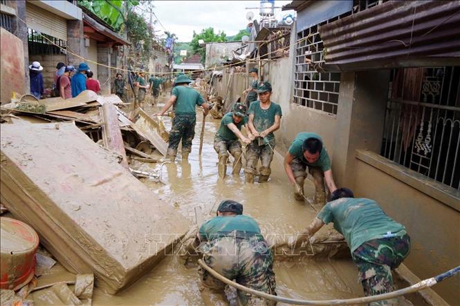 Lực lượng Sư đoàn 324 hỗ trợ người dân xã Tương Dương khắc phục hậu quả mưa lũ. Ảnh: TTXVN phát