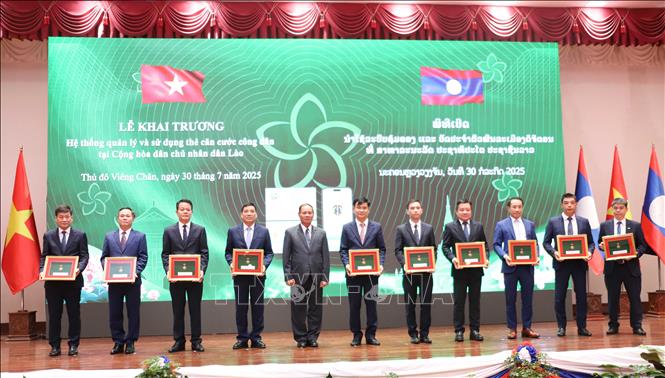 Bộ trưởng Bộ Công an Lào Vilay Lakhamphong trao các quyết định khen thưởng cho các tập thể có thành tích xuất sắc trong triển khai Dự án Hệ thống quản lý dân cư và căn cước công dân tại Lào. Ảnh: Xuân Tú - PV TTXVN tại Lào