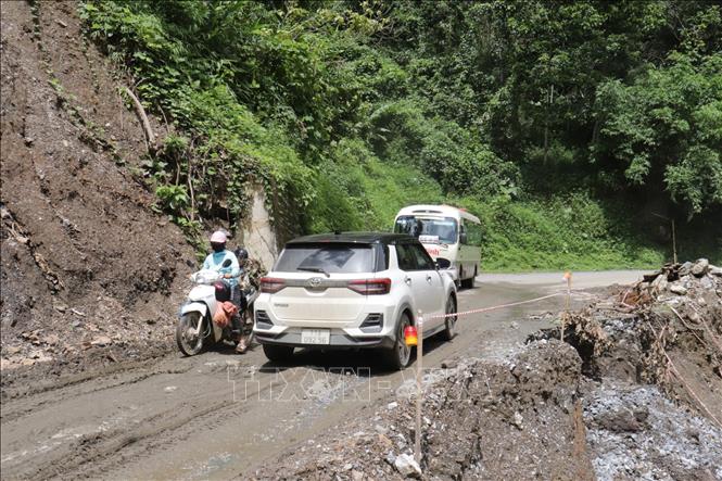 Các phương tiện khó khăn di chuyển qua đoạn sạt lở Km63 + 64 trên Quốc lộ 34. Ảnh: Minh Tâm-TTXVN