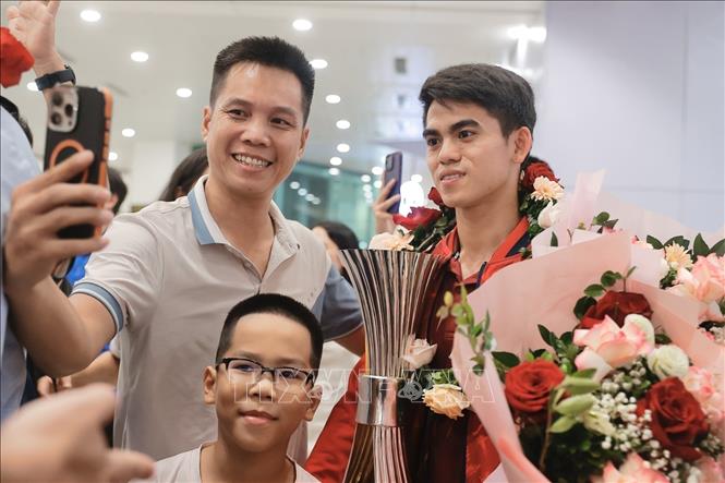 Đội trưởng Khuất Văn Khang chụp ảnh cùng người hâm mộ. Ảnh: Minh Quyết - TTXVN