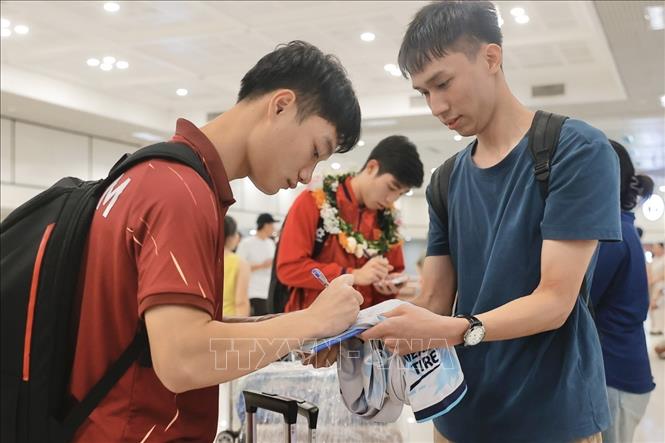 Cầu thủ ký tặng người hâm mộ. Ảnh: Minh Quyết - TTXVN