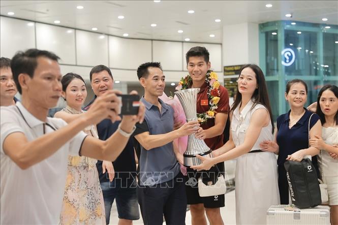 Trung vệ Hiểu Minh bên người thân và người hâm mộ tại sân bay Nội Bài. Ảnh: Minh Quyết - TTXVN