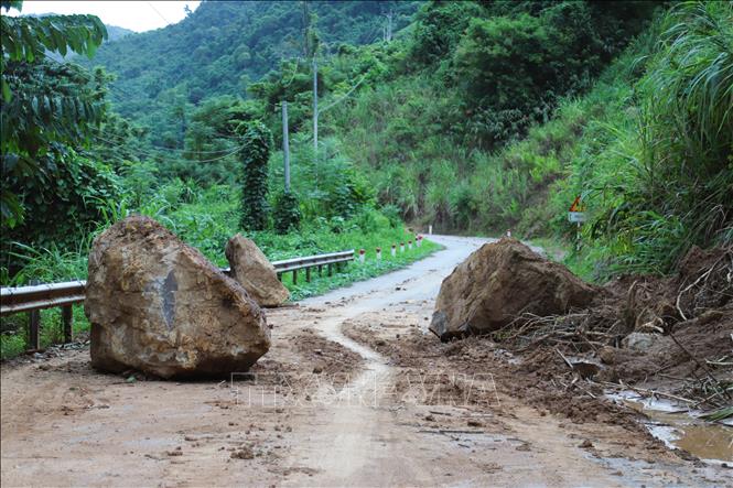 Những tảng đá kích thước lớn từ vách núi lăn xuống quốc lộ 16 tại một điểm có nguy cơ sạt lở, trụt trượt rất lớn, cách xã Nhôn Mai hơn 20km. Ảnh: Xuân Tiến - TTXVN  