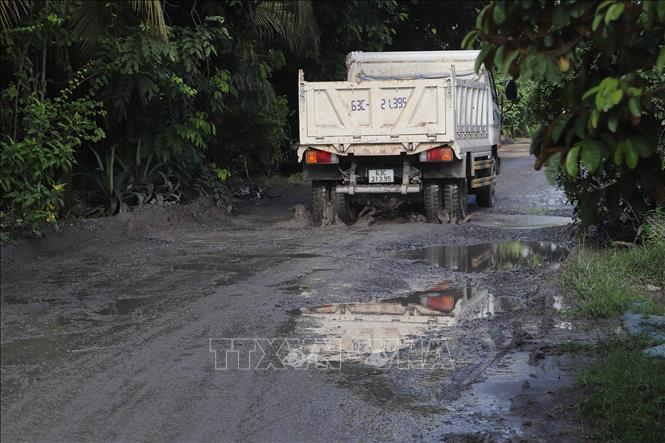 Phương tiện chở vật liệu xây dựng cày nát mặt đường. Ảnh: Minh Trí - TTXVN