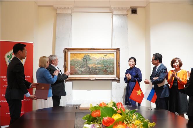 Phu nhân Ngô Phương Ly tặng bức tranh “Những đồi cọ” của cố họa sĩ Phan Kế An. Ảnh: Tâm Hằng - PV TTXVN tại Liên bang Nga