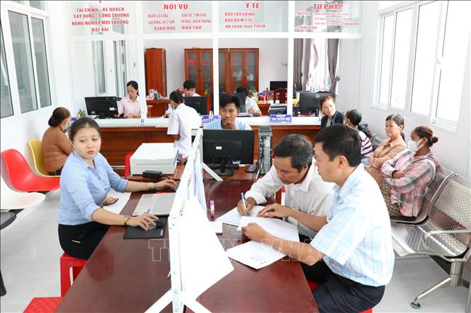 Người dân thực hiện thủ tục hành chính tại Trung tâm Phục vụ hành chính công xã Vinh Kim. Ảnh: Thanh Hòa - TTXVN