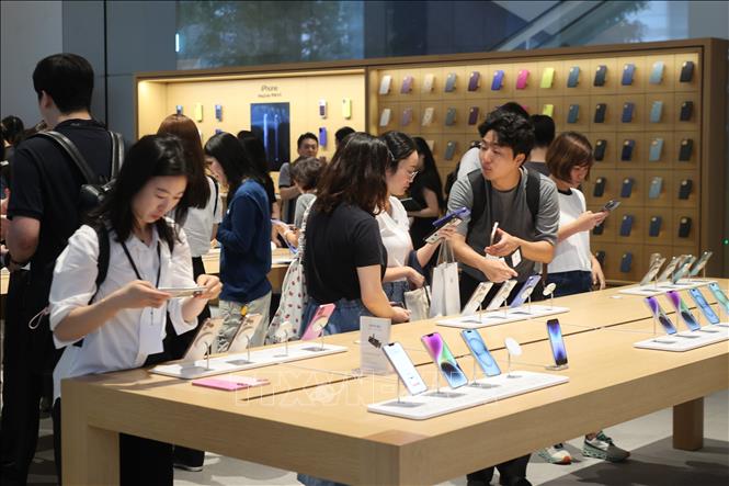 Khách hàng trải nghiệm điện thoại iPhone tại cửa hàng Apple ở Seoul, Hàn Quốc. Ảnh: Yonhap/TTXVN