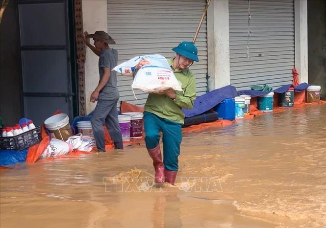 Vận chuyển tài sản của nhân dân xã Bó Sinh đến nơi an toàn. Ảnh: TTXVN phát