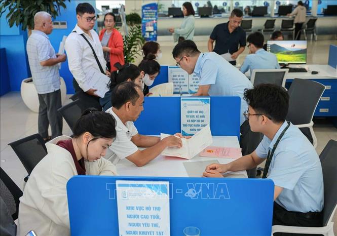 Công dân đến làm thủ tục hành chính được hướng dẫn, tư vấn miễn phí, giải đáp những thắc mắc về thủ tục đất đai. Ảnh: Hoàng Hiếu - TTXVN