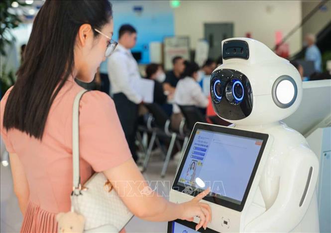 Robot lễ tân giúp hướng dẫn thủ tục, tra cứu thông tin, chỉ dẫn vị trí quầy thay cho con người, giảm áp lực cho nhân viên lễ tân. Ảnh: Hoàng Hiếu - TTXVN