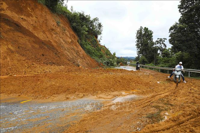 Sạt lở taluy dương khiến đất đá tràn ra mặt đường. Ảnh: TTXVN