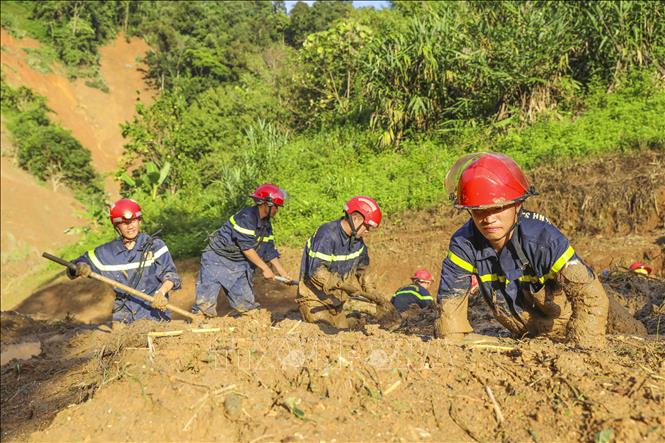 Các chiến sĩ Phòng cháy chữa cháy và Cứu nạn cứu hộ ngâm mình trong bùn đất để tìm kiếm các nạn nhân. Ảnh: Xuân Tư - TTXVN