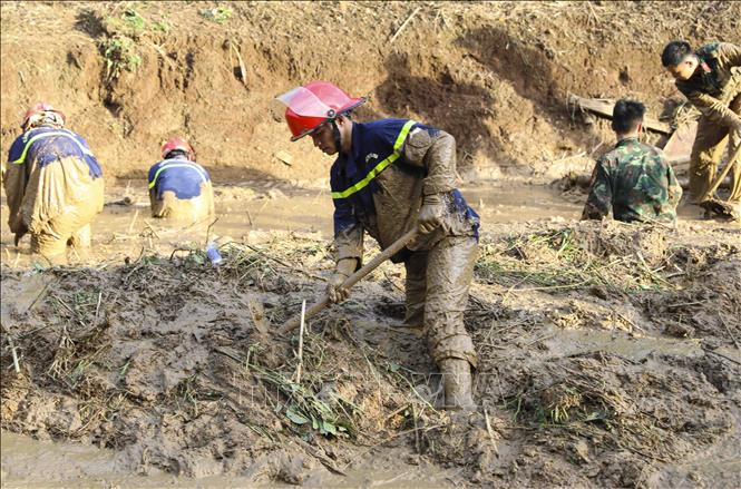 Lớp bùn dày đặc khiến công tác tìm kiếm gặp nhiều khó khăn. Ảnh: Xuân Tư - TTXVN