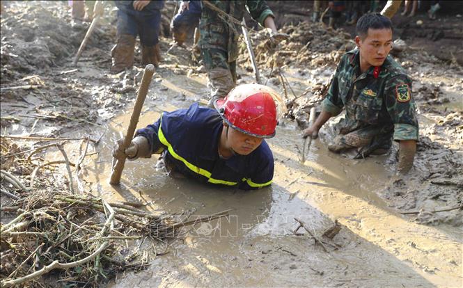 Các chiến sĩ nỗ lực tìm kiếm nạn nhân bị vùi lấp dưới lớp bùn đất. Ảnh: Xuân Tư - TTXVN