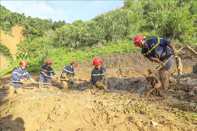 Lớp bùn dày đặc khiến công tác tìm kiếm gặp nhiều khó khăn. Ảnh: Xuân Tư - TTXVN