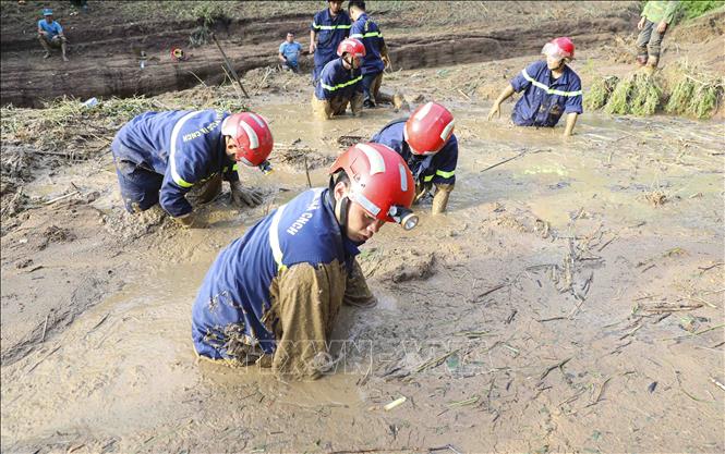 Các chiến sĩ nỗ lực tìm kiếm nạn nhân bị vùi lấp dưới lớp bùn đất. Ảnh: Xuân Tư - TTXVN
