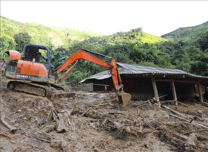 Máy xúc được huy động để khắc phục hậu quả lũ quét, sạt lở đất (ảnh chụp lúc 18g10 ngày 1/8). Ảnh: Xuân Tư - TTXVN
