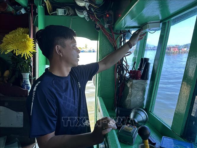 Tran Ngoc Hien, captain of vessel BD 98732TS from Gia Lai province, checks the vessel monitoring system (VMS) at Tho Quang port. VNA Photo: Đỗ Trưởng 