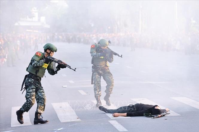 Biểu diễn tình huống bảo vệ yếu nhân. Ảnh: Minh Đức - TTXVN