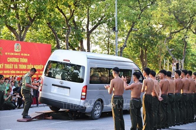 Cán bộ, chiến sĩ biểu diễn khí công ôtô đi trên ván chèn lên người. Ảnh: Minh Đức - TTXVN