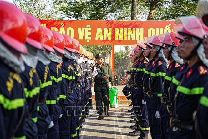 Dùng nước để phun làm mát cho các chiến sĩ trong điều kiện thời tiết nóng bức. Ảnh: Trung Kiên - TTXVN