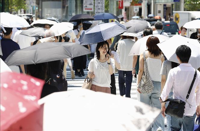Người dân di chuyển dưới trời nắng gắt tại Ginza, Nhật Bản ngày 23/7/2025. Ảnh: Kyodo/TTXVN