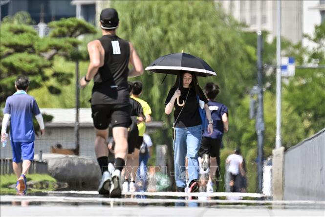 Người dân di chuyển dưới trời nắng gắt tại Tokyo, Nhật Bản. Ảnh: Kyodo/TTXVN