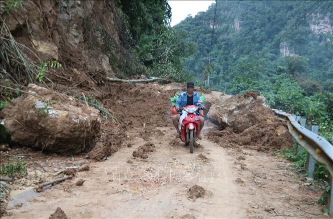 Người dân ở những bản làng, khu vực bị cô lập dùng xe máy đi nhận lương thực, phu yếu phẩm được hỗ trợ từ các hoạt động thiện nguyện. Ảnh: Xuân Tiến - TTXVN 