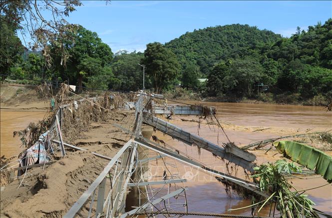 Cầu treo Đền Vạn (xã Tương Dương) bắc qua sông Lam bị lũ kéo sập và cuốn trôi trong rạng sáng ngày 23/7 gây chia cắt, cô lập bản làng, cụm dân cư bên kia sông với Quốc lộ 7. Ảnh: Xuân Tiến - TTXVN 