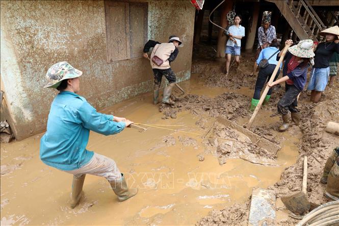 Người dân và lực lượng chức năng tích cực dọn dẹp bùn đất, vệ sinh nhà cửa. Ảnh: Trung Kiên - TTXVN