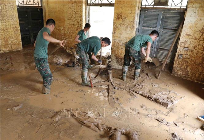 Lực lượng quân đội thu dọn bùn đất tại điểm trường mầm non Suối Lư. Ảnh: Trung Kiên - TTXVN