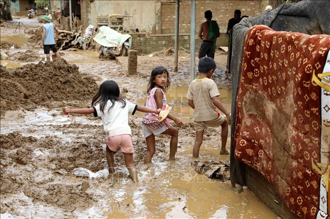 Bùn đất vùi lấp khiến việc đi lại của nhân dân gặp rất nhiều khó khăn. Ảnh: Trung Kiên - TTXVN