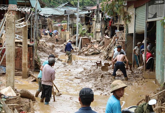 Người dân và lực lượng chức năng tích cực dọn dẹp bùn đất, vệ sinh nhà cửa. Ảnh: Trung Kiên - TTXVN