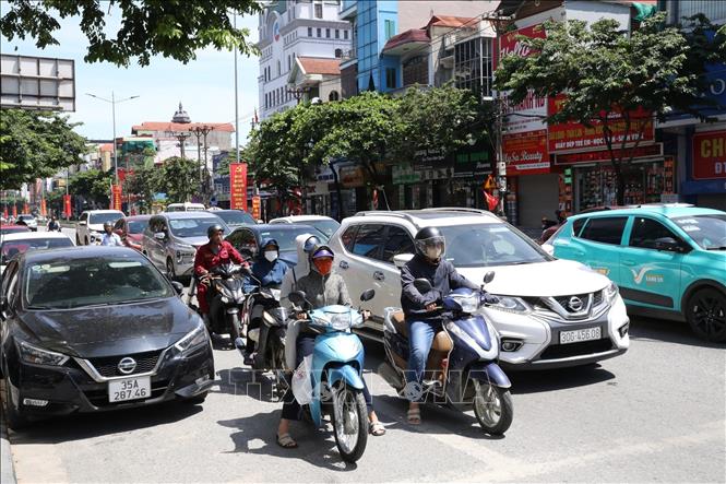 Người dân nai nịt kín mít khi đi ra đường do thời tiết quá nóng bức. Ảnh: Đức Phương - TTXVN