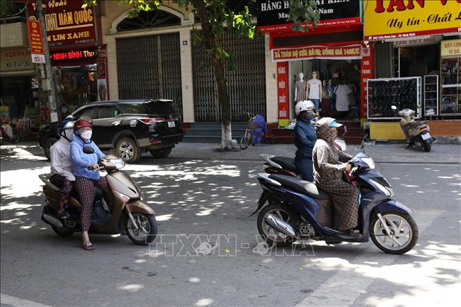 Người dân ra đường với trang phục kín mít. Ảnh: Đức Phương - TTXVN
