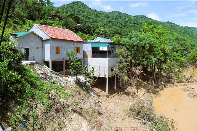 Những ngôi nhà bên bờ vực sạt lở trên sông Lam đối diện với nguy cơ tái diễn tình trạng sạt lở, uy hiếp tài sản, tính mạng người dân nếu trời tiếp tục mưa. Ảnh: Xuân Tiến - TTXVN 