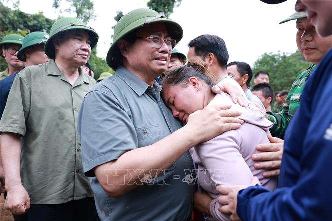Thủ tướng Phạm Minh Chính động viên gia đình có người chết do mưa lũ ở xã Xa Dung. Ảnh: Dương Giang-TTXVN 
