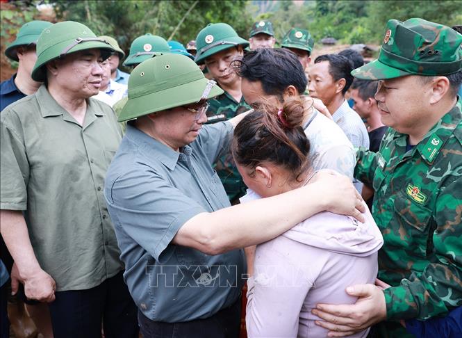 Thủ tướng Phạm Minh Chính động viên gia đình có người chết do mưa lũ ở xã Xa Dung. Ảnh: Dương Giang-TTXVN 

