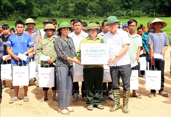 Phó Thủ tướng Lê Thành Long tặng quà cho lãnh đạo xã Chiềng Sơ. Ảnh: Quang Quyết - TTXVN