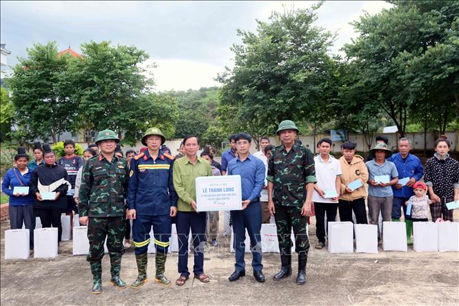 Trao quà của Phó Thủ tướng Lê Thành Long cho lãnh đạo xã Huổi Một. Ảnh: Quang Quyết - TTXVN