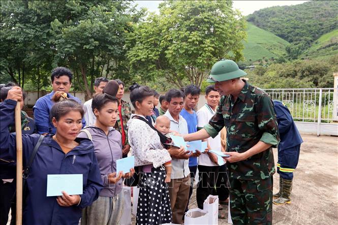 Trao tặng quà của Phó Thủ tướng Lê Thành Long cho nhân dân xã Huổi Một. Ảnh: Quang Quyết - TTXVN 