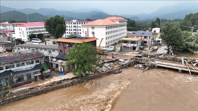 Một đoạn đường và cây cầu bị hư hại do lũ quét tại Thiên Tân, Trung Quốc ngày 28/7/2025. Ảnh: THX/TTXVN