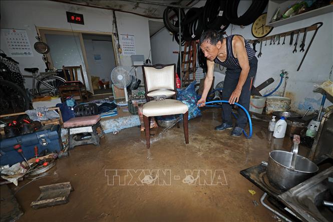 Người dân dọn nước lũ tràn vào nhà ở thành phố Gwangju, Hàn Quốc ngày 4/8/2025. Ảnh: Yonhap/TTXVN
