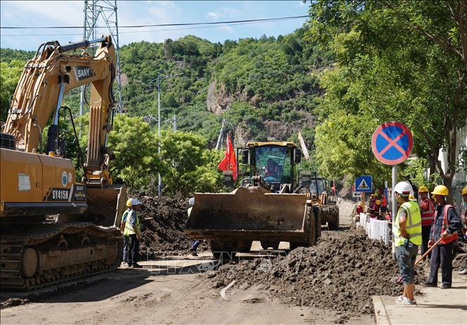 Dọn dẹp bùn đất sau mưa lũ tại Hoài Nhu, Bắc Kinh, Trung Quốc. Ảnh: THX/TTXVN