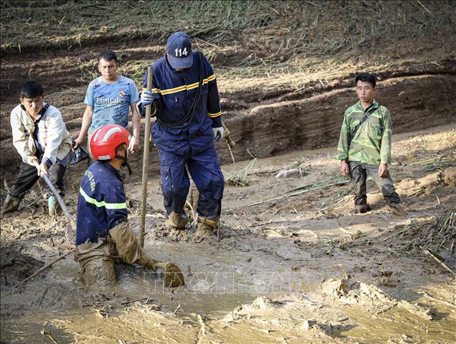 Trưởng bản Mùa A Thi (ngoài cùng bên phải) cùng lực lượng chức năng tìm kiếm các nạn nhân mất tích do sạt lở, lũ quét ở bản Háng Pu Xi, xã Xa Dung, sáng 2/8. Ảnh: Xuân Tư - TTXVN