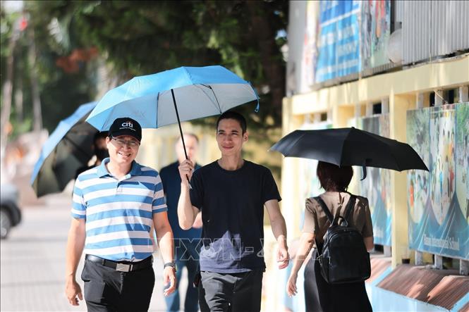Nhiều người dân sử dụng ô khi di chuyển trên phố dưới trời nắng gay gắt. Ảnh: Lê Đông - TTXVN