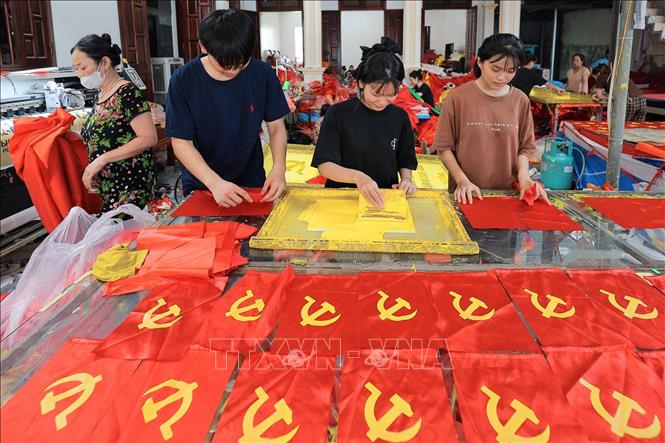 Từng công đoạn, từng lá cờ được người dân nơi đây thực hiện một cách tỉ mỉ. Ảnh: Lê Đông - TTXVN 