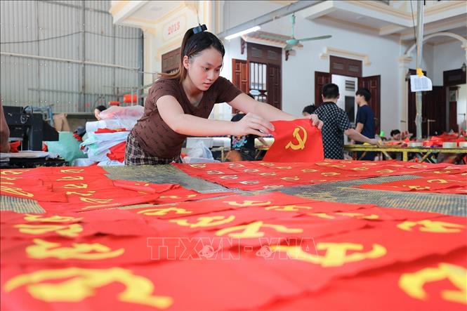 Từng công đoạn, từng lá cờ được người dân nơi đây thực hiện một cách tỉ mỉ. Ảnh: Lê Đông - TTXVN 